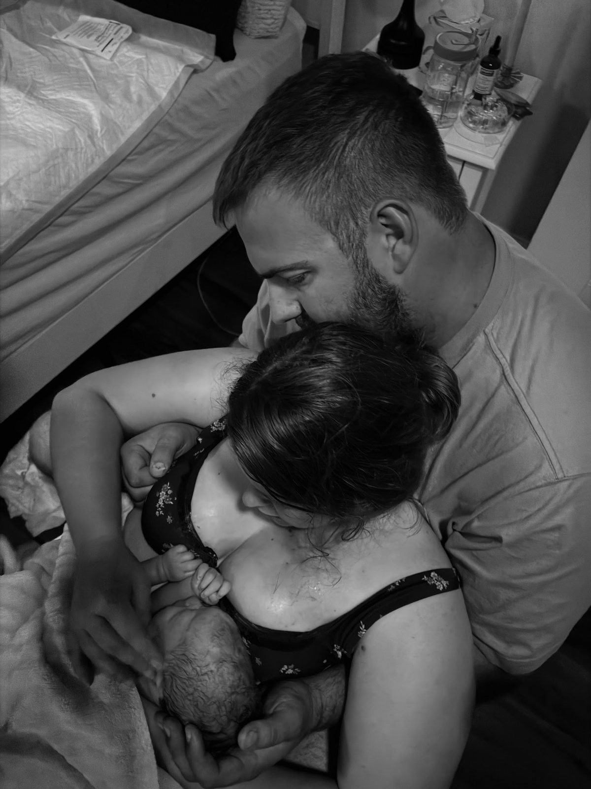 New parents resting in bed with their newborn